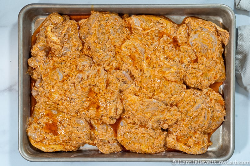 Greek Chicken Bowl marinating chicken on a tray