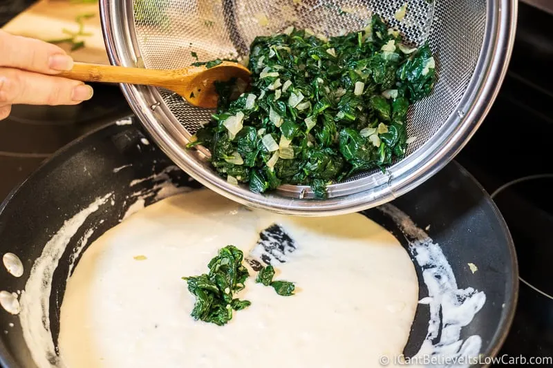 adding spinach to pan for Keto Creamed Spinach recipe