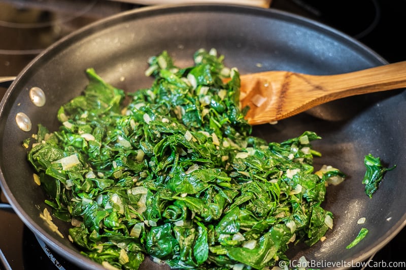 sautéing Spinach in a pan on the stove