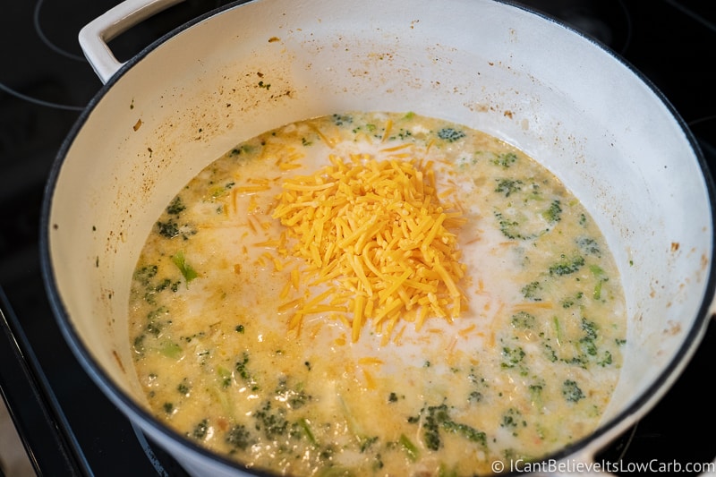 mixing cheese to Keto Broccoli Cheddar Soup