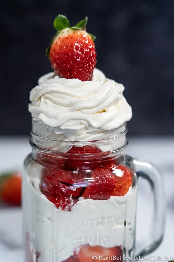 Jar of Keto Sugar-Free Whipped Cream with a strawberry on top