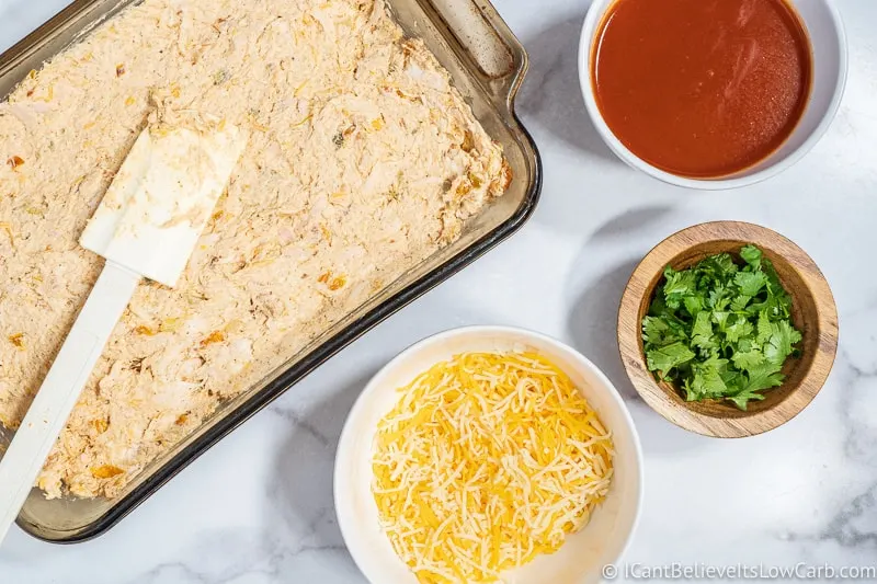putting low carb Chicken Enchilada Casserole in baking dish