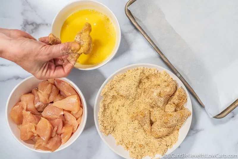 Keto Chicken Nuggets dipping in almond flour