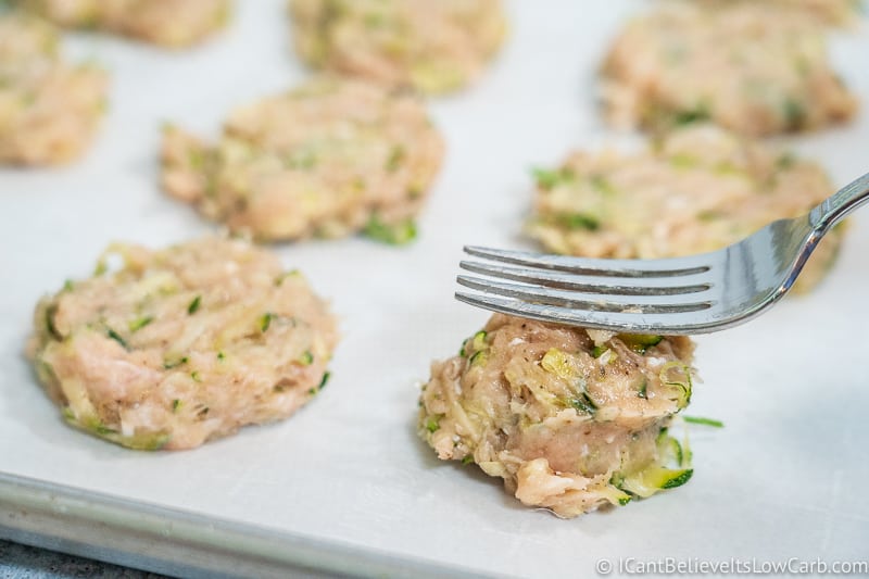 flattening Chicken Zucchini Poppers with a fork