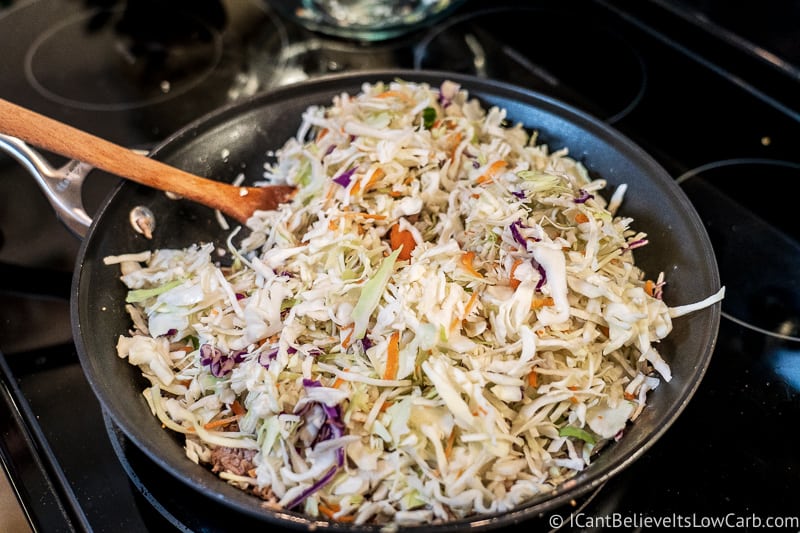 mixing cabbage with Keto Crack Slaw