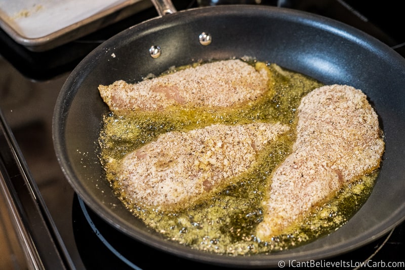 frying Keto Chicken Parmesan in a pan on the stove