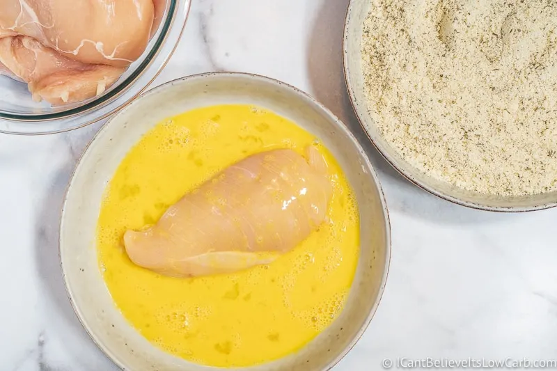 dipping chicken in egg for Keto Chicken Parmesan