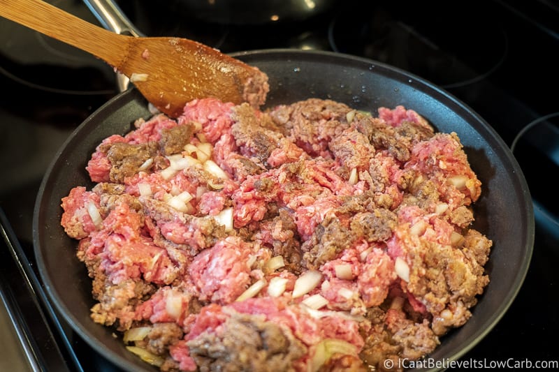 ground beef sausage and onions frying in pan
