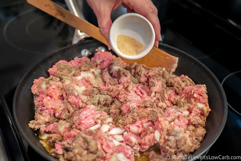 adding garlic to meat for Keto Stuffed Peppers