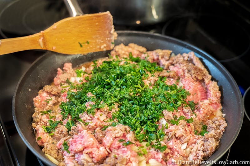 adding parsley to meat for Keto Stuffed Peppers