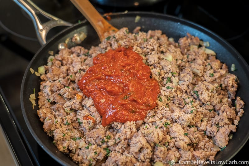 mixing tomato sauce to filling for Low Carb Keto Stuffed Peppers