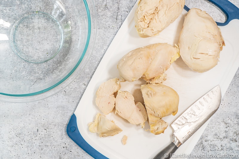 cutting poached chicken for Keto chicken salad