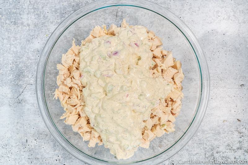 mixing creamy dressing and chopped chicken