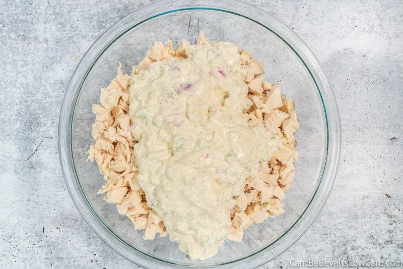 mixing creamy dressing and chopped chicken