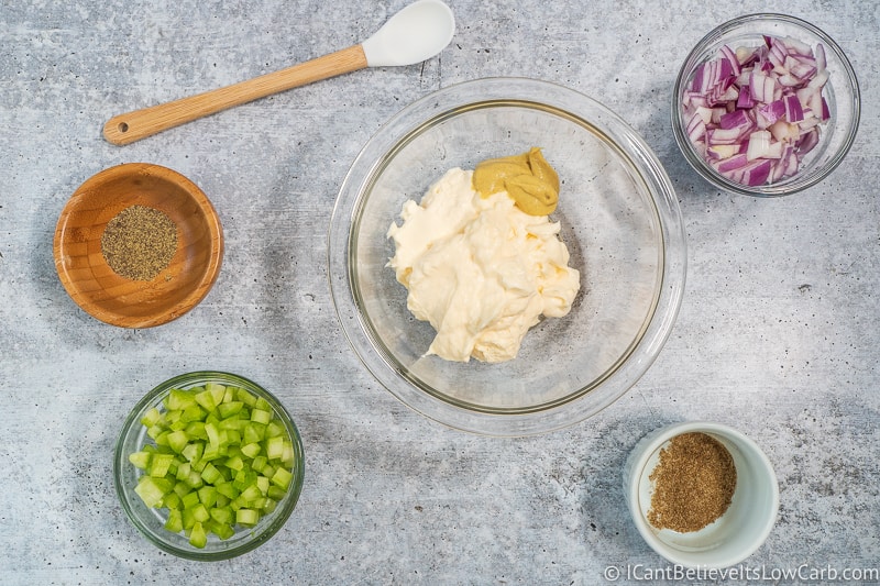 adding mustard to bowl with Chicken Salad ingredients