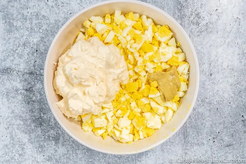 mayo and mustard in a bowl of chopped eggs