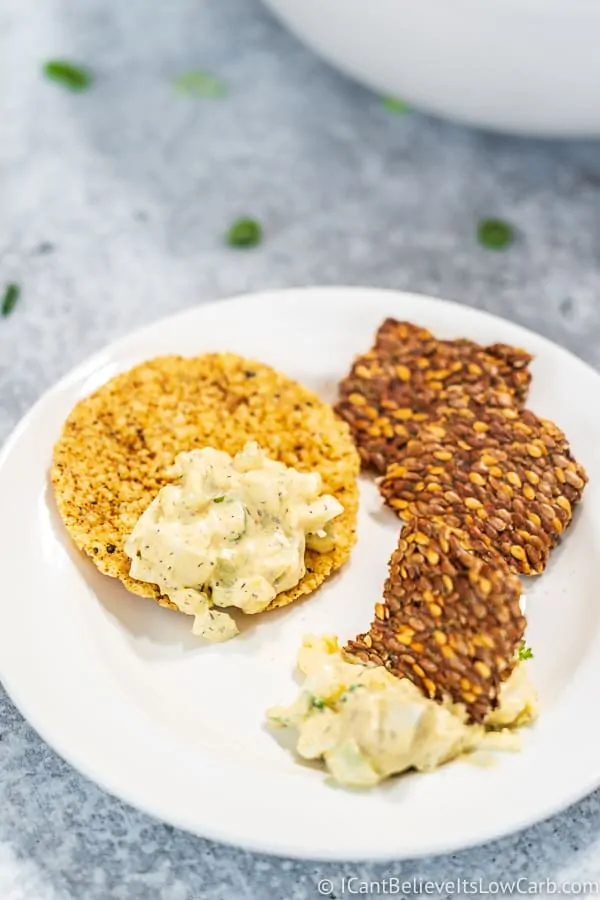 scooping Keto Egg Salad on crackers
