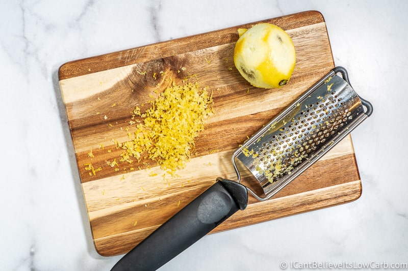 fresh lemon zest on cutting board and grater