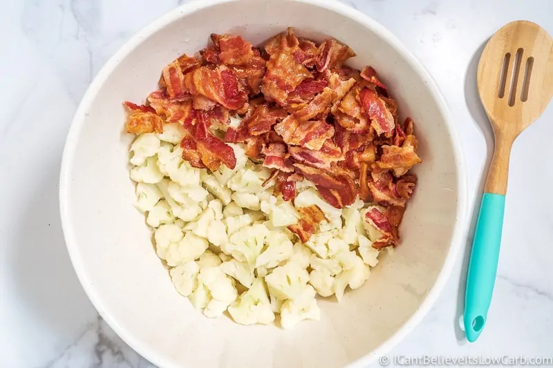 adding bacon to Keto Cauliflower Potato Salad