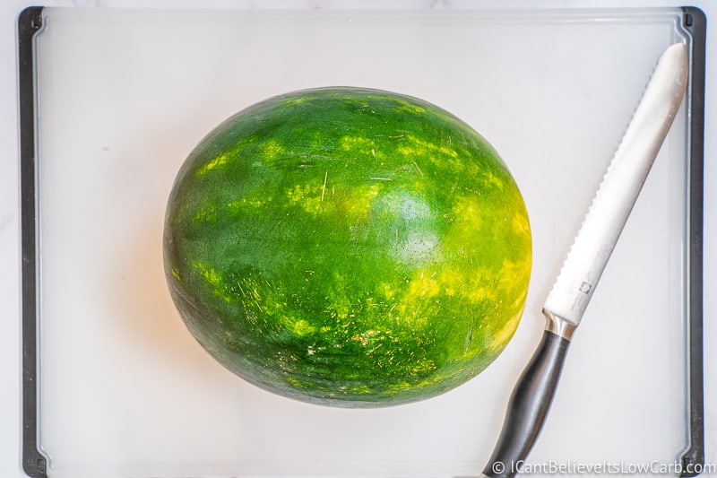 green Watermelon on cutting board with knife