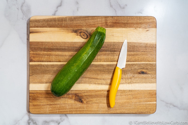 one Zucchini on cutting board with knife