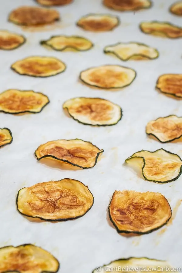 zucchini chips laying on a baking sheet
