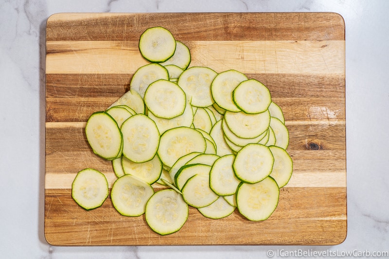 Paper-thin Zucchini sliced into Chips on cutting board