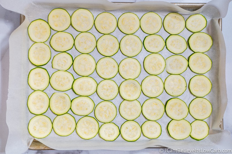 Baking sheet pan full of thinly sliced Zucchini