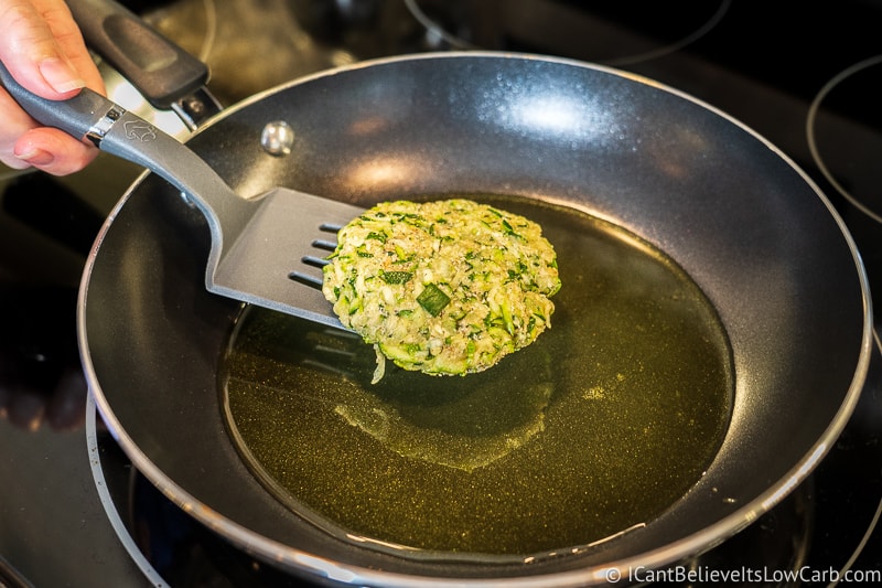 placing Zucchini Fritters in oil to fry