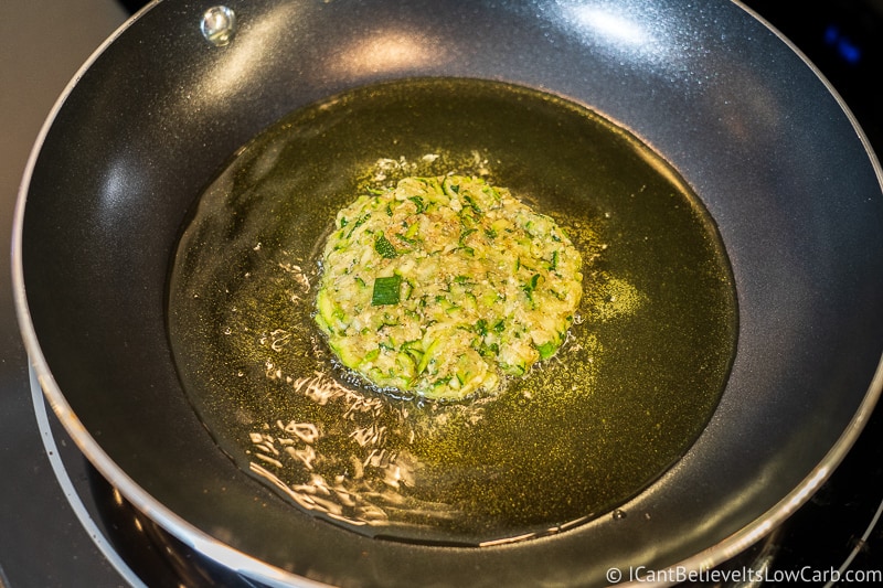 One Zucchini Fritter in frying pan with oil