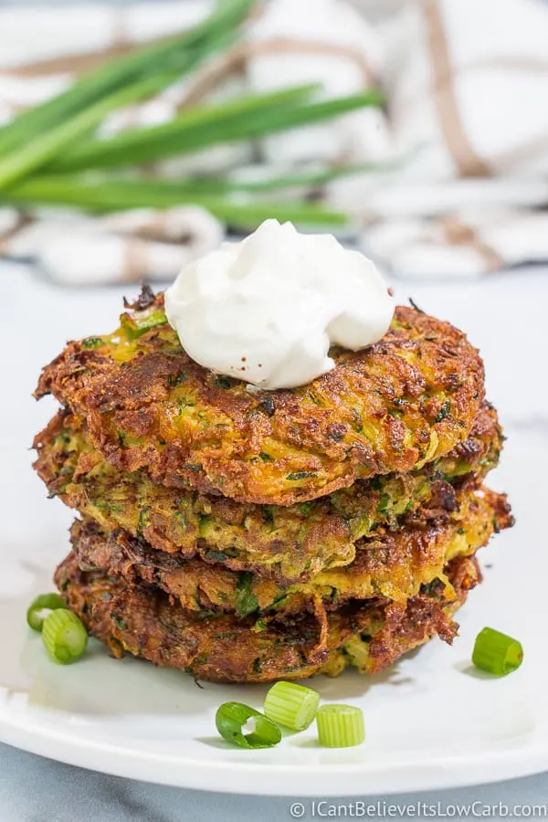 Pile of Keto Zucchini Fritters with sour cream