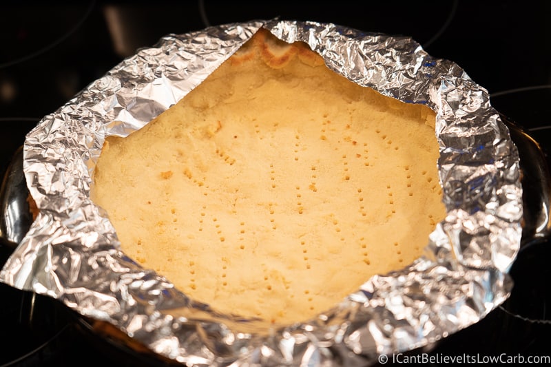 Coconut Flour Pie Crust baking in the oven with pie shield