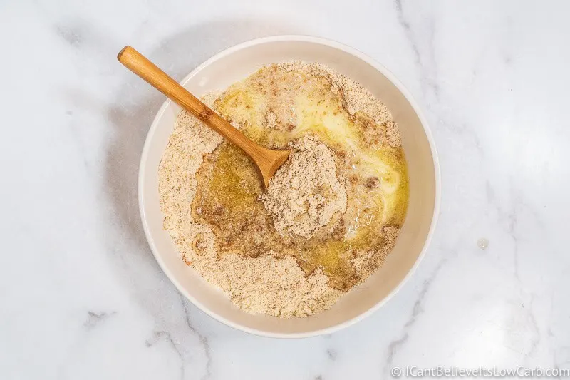 pouring butter in dry Keto Cheesecake ingredients