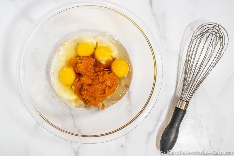 mixing eggs and pumpkin puree for pumpkin muffins