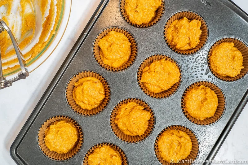 Muffin liners filled with low carb pumpkin muffin mixture