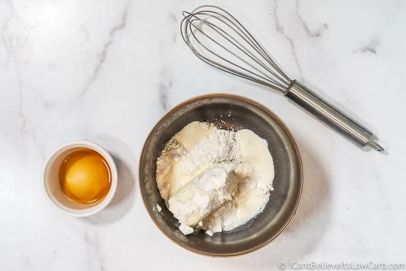 adding heavy cream to frosting mixture