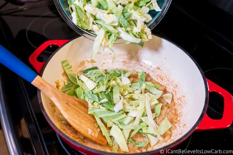 adding cabbage to pan