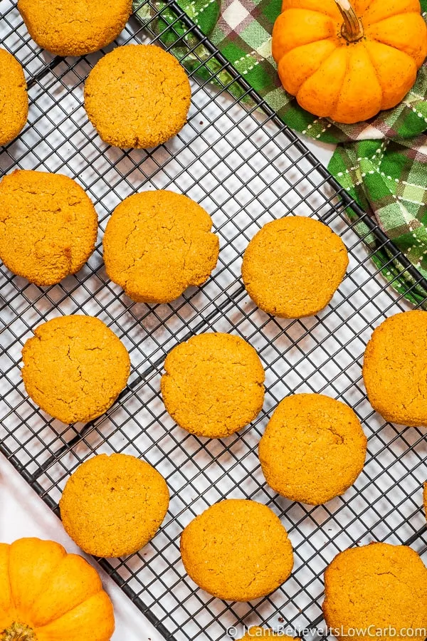 Keto Pumpkin Cookies cooling on a rack with pumpkins