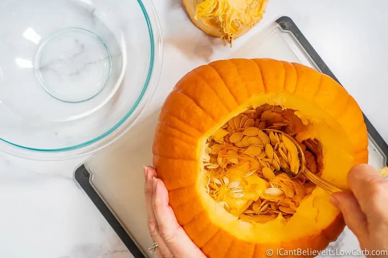 Scooping Pumpkin Seeds out of a pumpkin with a spoon