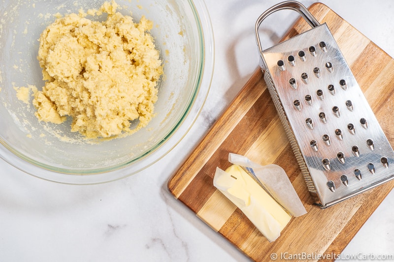 Keto Biscuit dough in a bowl and box grater and butter