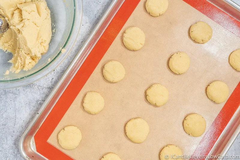Pressing Cream Cheese Cookies on tray