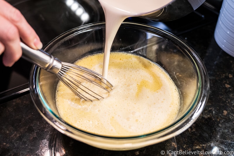 adding cream mixture to eggs