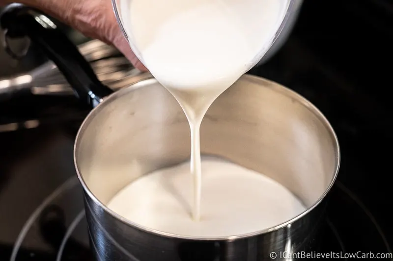 pouring heavy cream into the pot