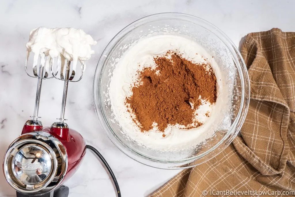 adding cocao powder to whipped cream