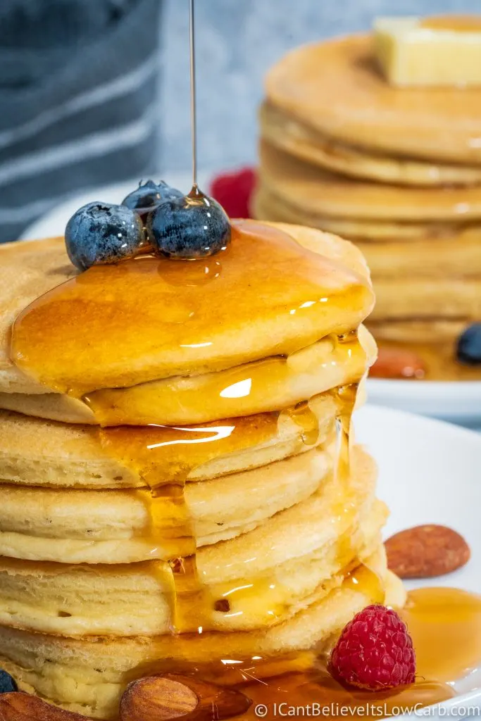 Pouring low carb maple syrup on a stack of Almond Flour Pancakes