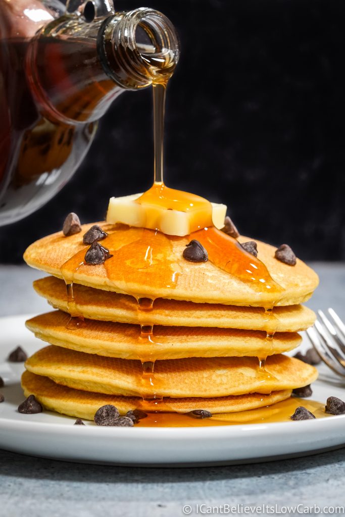 pouring maple syrup on Keto Pancakes