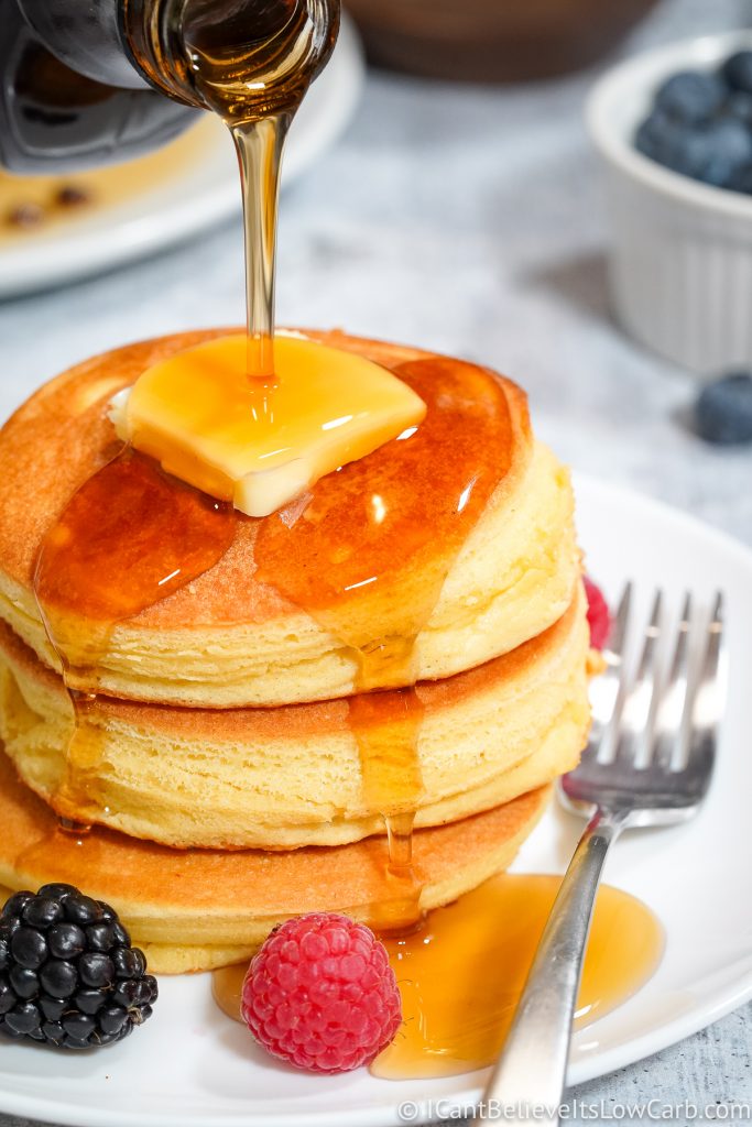 pouring syrup on a stack of Keto Pancakes