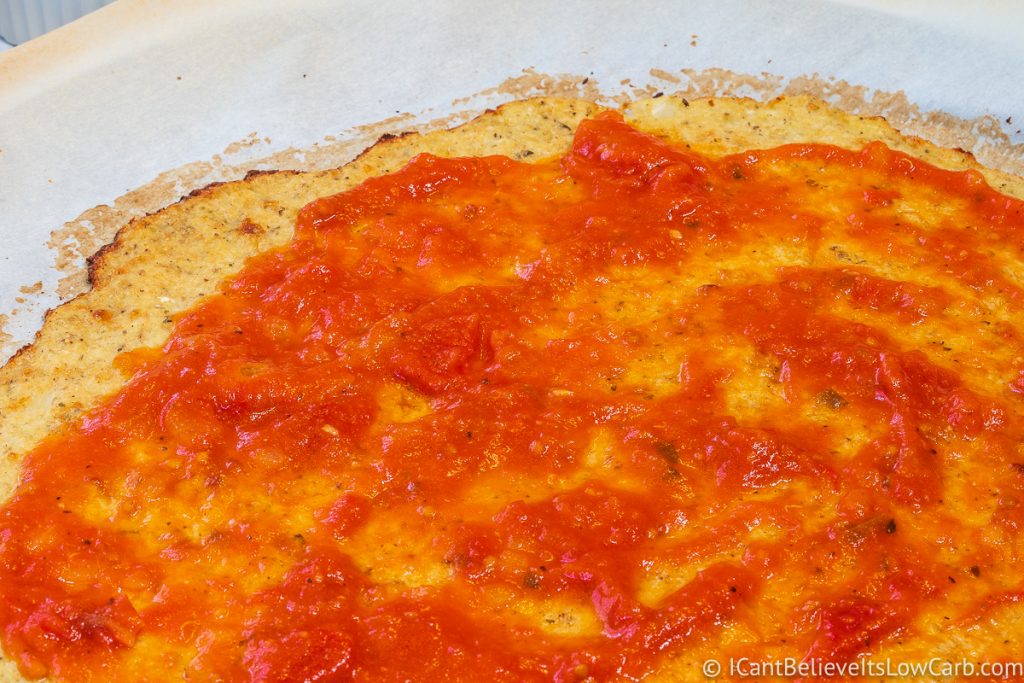Cauliflower Pizza Crust with pizza sauce covering it