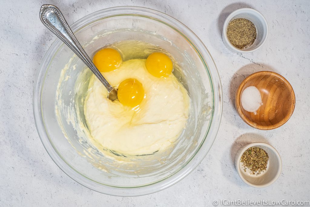 adding eggs to cheese mixture