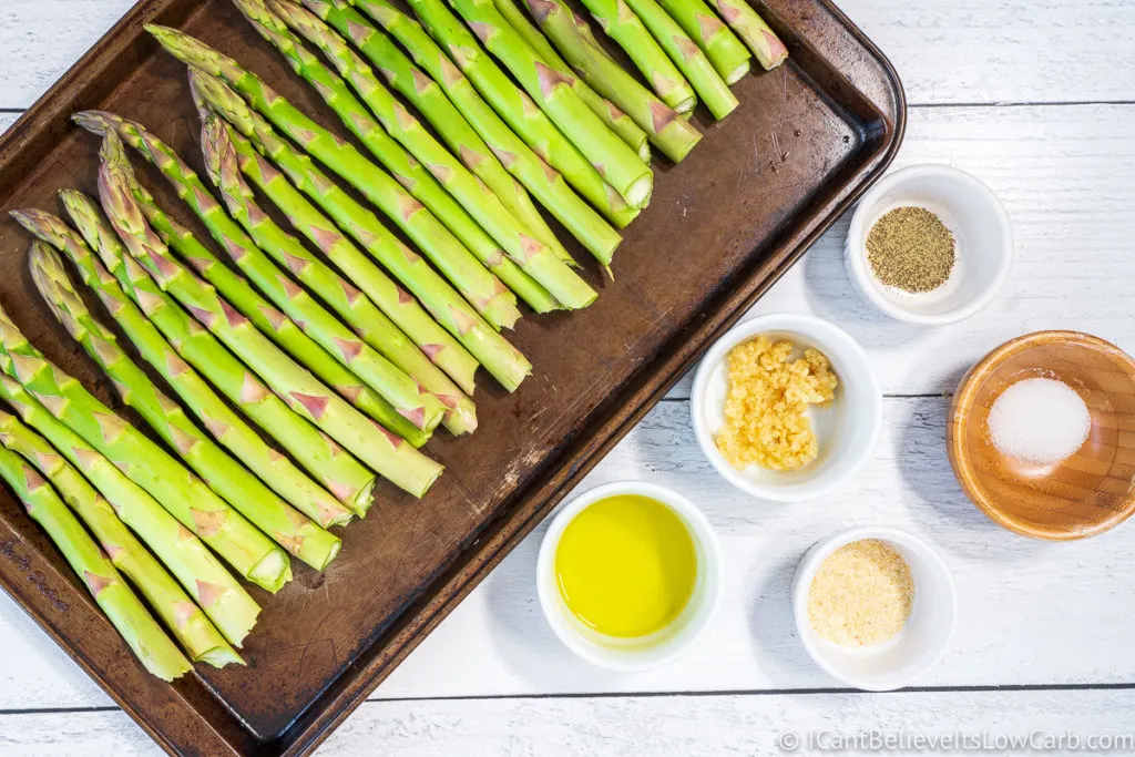 Asparagus on baking sheet with ingredients